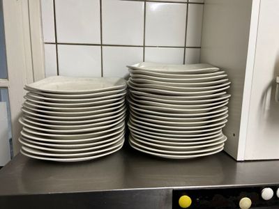 de nombreuses assiettes empilées sur le plan de travail de la cuisine