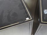 two black metal cabinets with pictures on them in a room