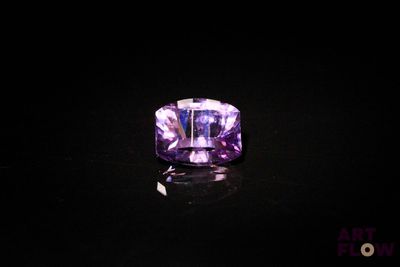 une bague en améthyste ornée d'une pierre violette sur un fond noir