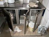 a stainless steel counter top with two open doors
