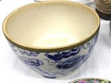 a blue and white bowl sitting on a table next to a plate
