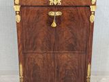 a wooden chest of drawers with a marble top