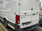 a white van parked in a parking lot next to a car