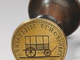brass plated stamp with a picture of a wagon on it