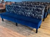 un banc bleu dans une pièce où se trouvent des chaises