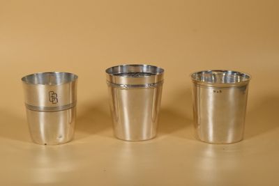 trois tasses en métal posées les unes à côté des autres sur une table