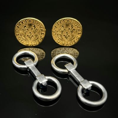 deux paires de boutons de manchette en or et en argent sur un fond noir