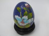 an image of a blue egg with a flower painted on it