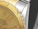 a watch with a gold dial on a black background