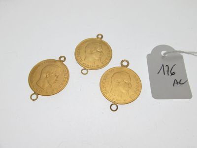 un lot de quatre breloques en forme de pièces d'or, avec une étiquette de prix