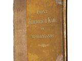 un vieux livre à la couverture brune posé sur une surface blanche