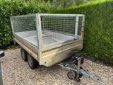 une petite remorque équipée d'une cage à l'arrière