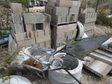 a pile of concrete blocks and a wheelbarrow on the ground