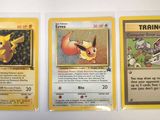 three pokemon cards are on display on a white surface