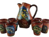 six cups and a pitcher sitting next to each other