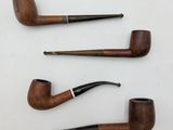 three pipe holders are lined up on a white surface
