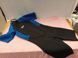 a blue and black wet suit laying on a pink bed