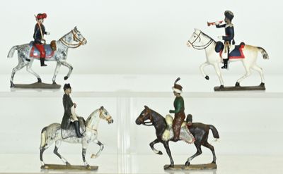 four figurines of people riding horses on display