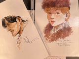 two drawings of a man and a woman are on a table
