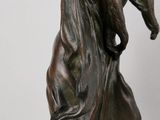 bronze statue of a woman holding a cat on her back