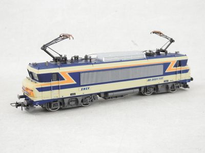 un train bleu et jaune sur les rails, sur un fond blanc