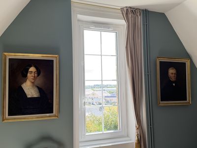 deux tableaux accrochés au mur d'une chambre, près d'une fenêtre