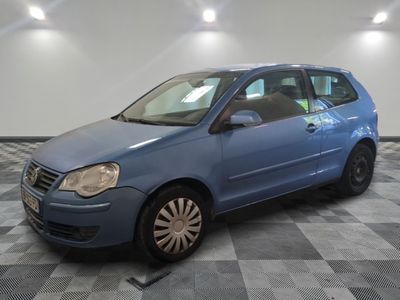 La voiture bleue est garée sur le sol à damier du garage.