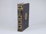 an old book sitting on top of a white table next to a white wall