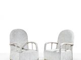 two white chairs sitting next to each other on top of a white floor