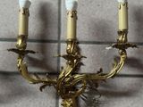 a three light wall sconce that is on the wall