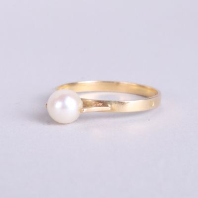 gros plan d'une bague en perle sur une surface blanche