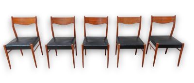 set of four dining chairs with black leather seats on a white background