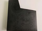 a close up of a piece of black paper on a white surface