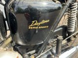 a close up of a black motorcycle with a yellow logo on it