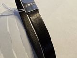 bracelet en cuir noir avec un fermoir argenté sur un fond blanc