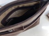the inside of a brown purse with a zipper on it