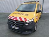 La camionnette est garée devant un immeuble orné d'une bande jaune et rouge.
