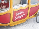 a yellow and red carriage with a red and white sign on it