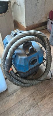 a blue vacuum cleaner sitting on the floor next to a bucket