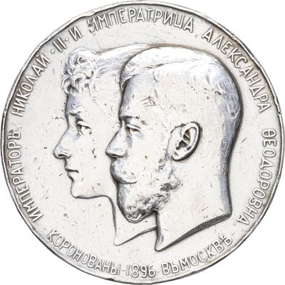 an image of a silver coin with two heads of a man and a woman on it
