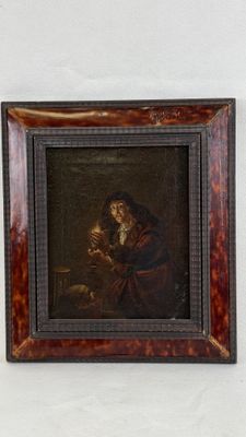 un vieux tableau représentant une femme tenant un bébé dans ses bras, dans un cadre en bois