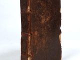 an old book is sitting on a white surface with a white background