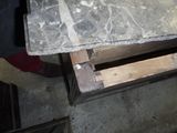 une personne debout à côté d'une table au plateau en marbre