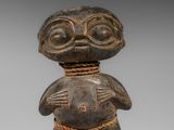 une figurine en bois représentant un homme aux grands yeux
