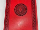 an old red book with a black and red design on it