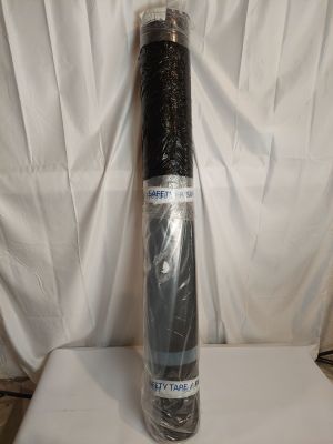 un rouleau de tissu noir posé sur une surface blanche