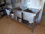 two sinks in the kitchen with pots and pans on the counter