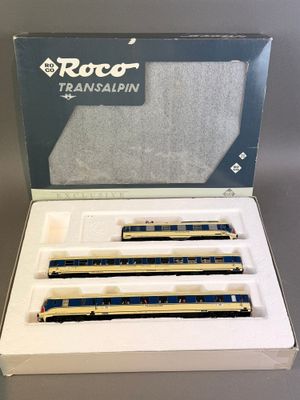 trois wagons bleus et blancs se trouvent dans une boîte posée sur une table