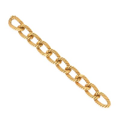 gros plan d'un bracelet en or sur fond blanc