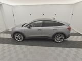 a grey car is parked in a garage with a checkered floor
